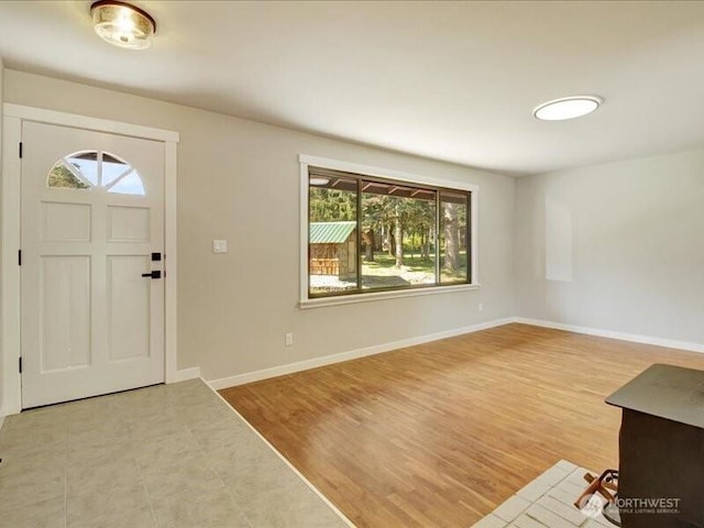 foyer entrance with wood finished floors and baseboards