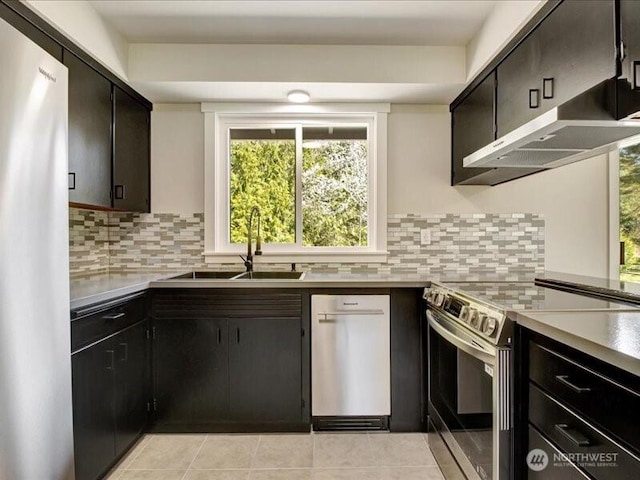 kitchen with tasteful backsplash, light tile patterned floors, stainless steel appliances, and a sink