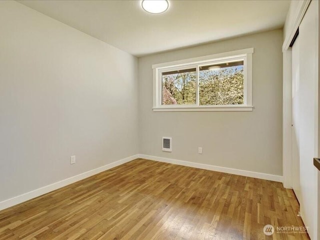 unfurnished bedroom featuring a closet, light wood-type flooring, visible vents, and baseboards