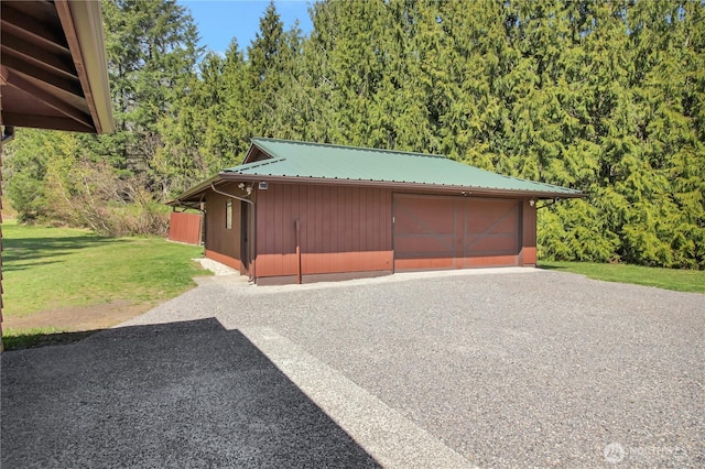 detached garage featuring a view of trees