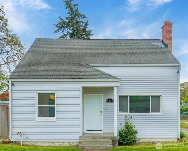 view of front of home featuring roof with shingles and a chimney