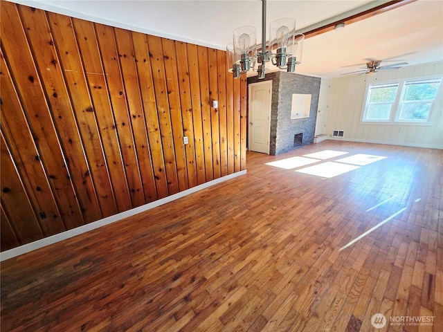 6818 Olympic Hwy, Aberdeen, WA 98520 - unfurnished dining area with wood-type flooring, visible vents, wooden walls, and ceiling fan with notable chandelier