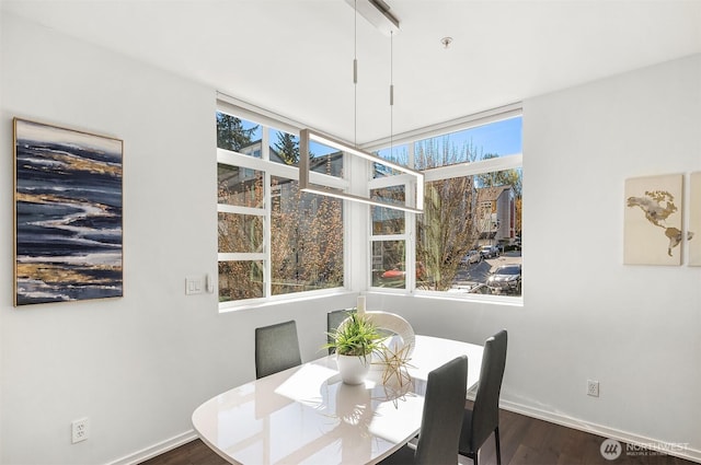 dining space with dark wood finished floors and baseboards