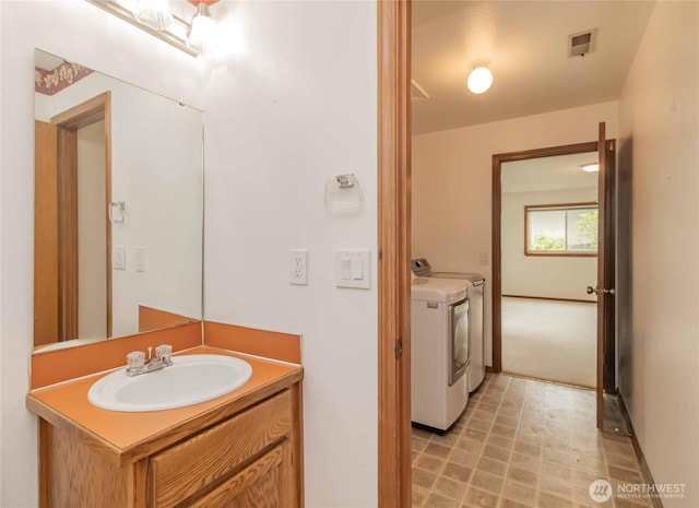 bathroom with washing machine and dryer and vanity