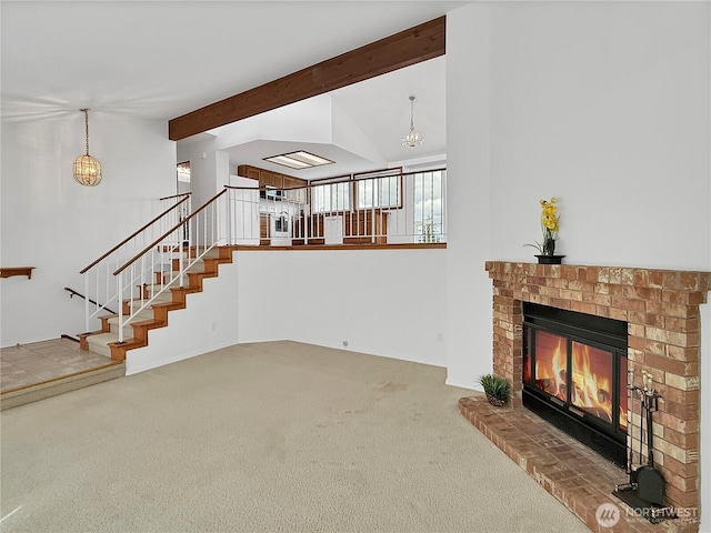 unfurnished living room featuring stairs, beamed ceiling, carpet flooring, a brick fireplace, and high vaulted ceiling
