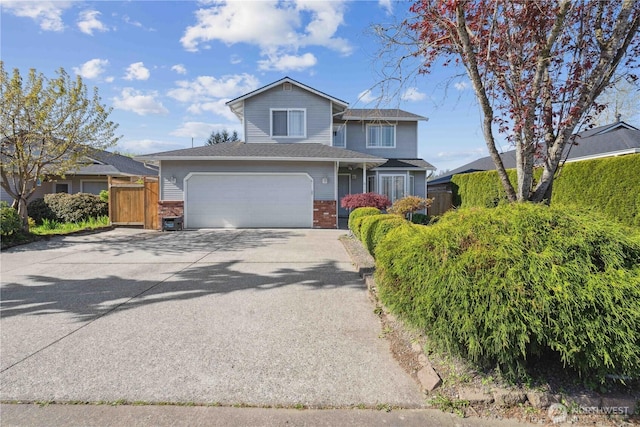 view of front facade featuring brick siding, an attached garage, driveway, and fence