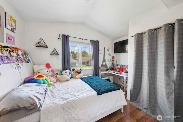 bedroom with lofted ceiling and wood finished floors