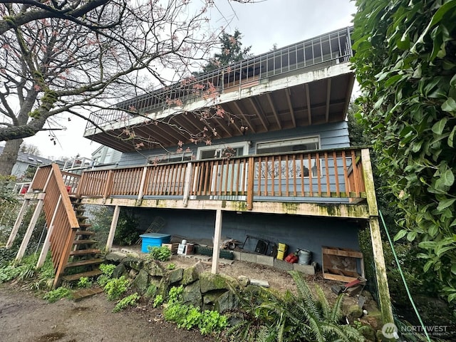 back of house with a wooden deck and stairway