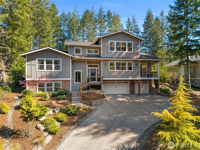 bi-level home with board and batten siding, driveway, brick siding, and a garage