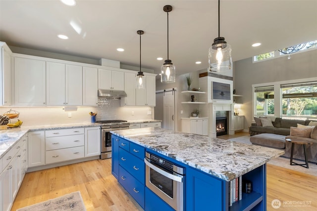 kitchen with blue cabinets, white cabinets, stainless steel range with gas stovetop, open shelves, and under cabinet range hood