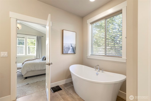 full bath featuring a freestanding bath, ensuite bath, tile patterned floors, and baseboards