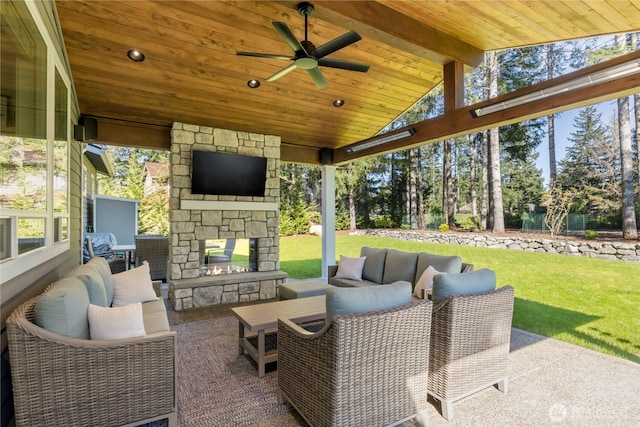 view of patio / terrace featuring an outdoor living space with a fireplace and a ceiling fan
