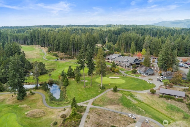 aerial view featuring a water and mountain view, a wooded view, and golf course view
