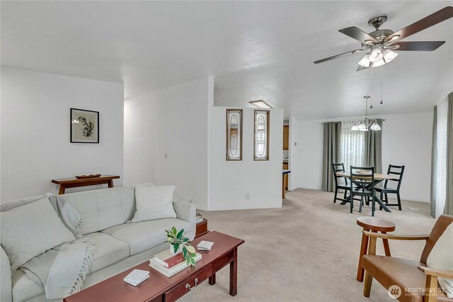 living room featuring light carpet, a chandelier, and ceiling fan