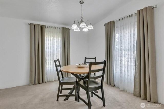dining space featuring a chandelier and light colored carpet
