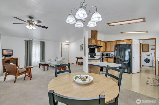 dining space featuring a chandelier, ceiling fan, washing machine and clothes dryer, lofted ceiling, and light carpet