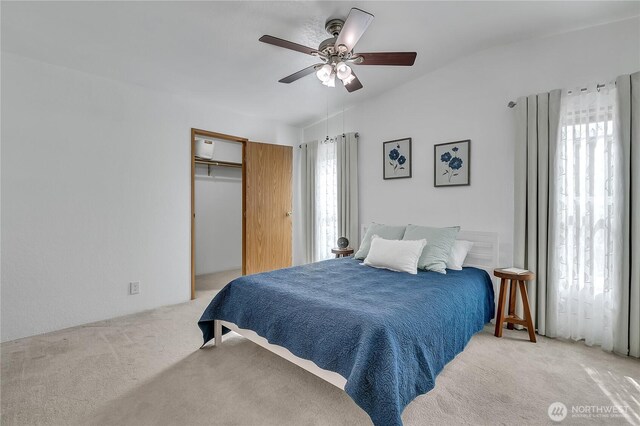 bedroom featuring light carpet, vaulted ceiling, and a ceiling fan