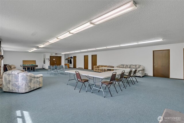 dining space featuring a textured ceiling, carpet flooring, and baseboard heating