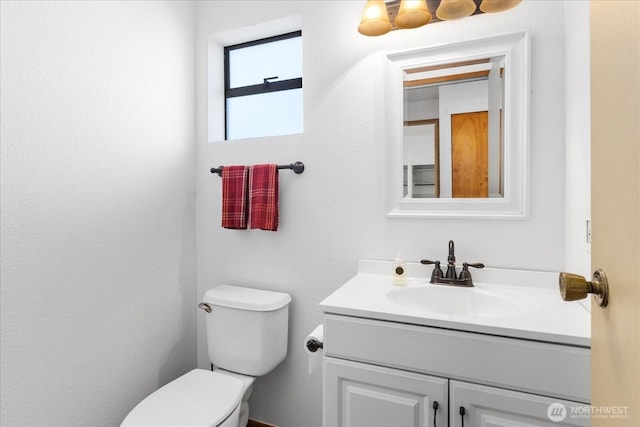 half bathroom with toilet and vanity