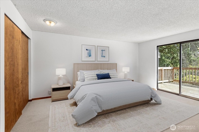 bedroom with a closet, a textured ceiling, carpet flooring, and access to outside
