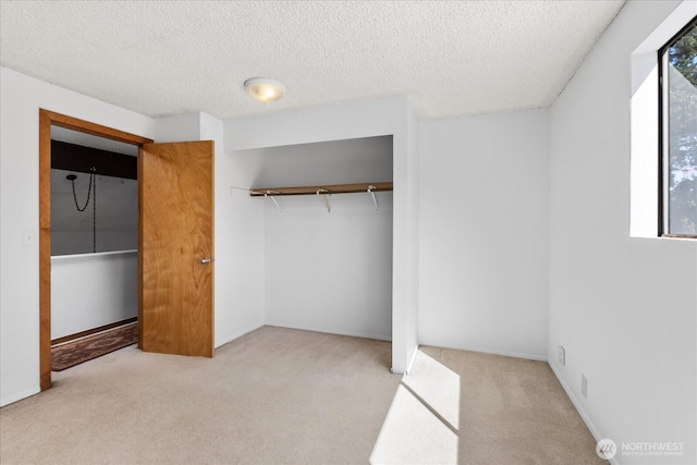 unfurnished bedroom with a textured ceiling, carpet floors, and a closet