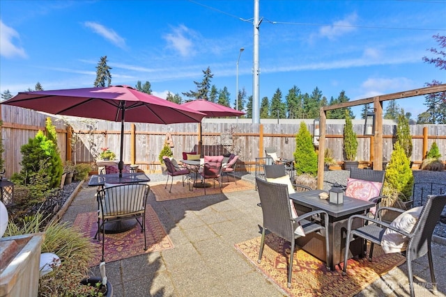 view of patio with outdoor dining space and a fenced backyard