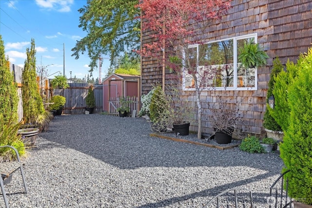 exterior space featuring a storage shed, an outbuilding, and fence