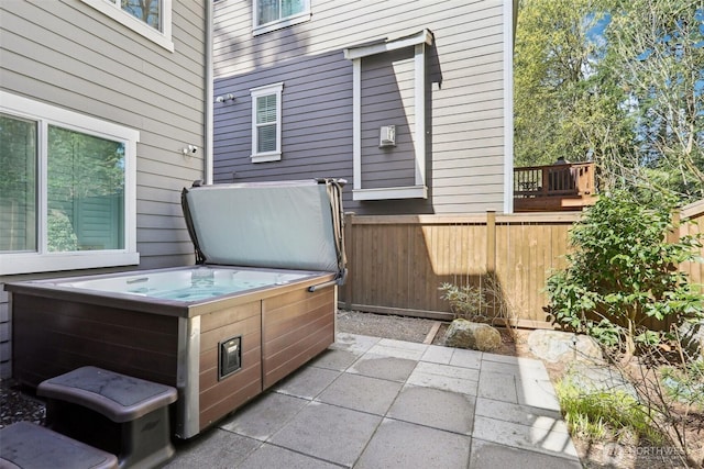 view of patio with fence and a hot tub