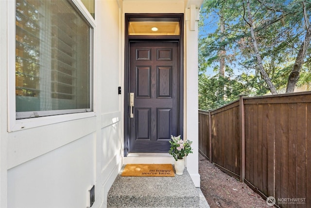 view of exterior entry featuring fence