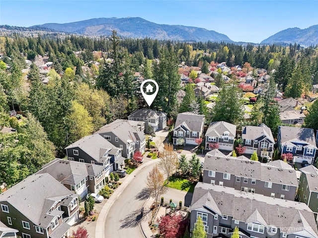 birds eye view of property featuring a residential view, a wooded view, and a mountain view