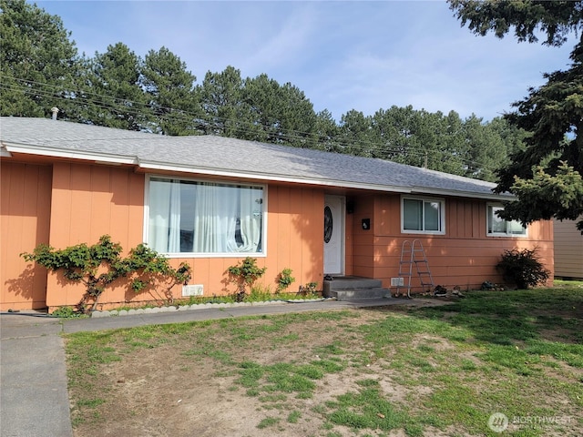ranch-style home featuring board and batten siding and a front lawn