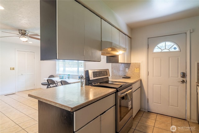775 S 4th Ave, Othello, WA 99344 - kitchen featuring electric range, under cabinet range hood, light tile patterned floors, plenty of natural light, and recessed lighting