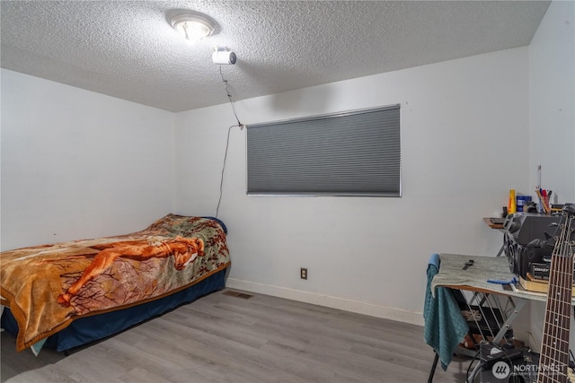775 S 4th Ave, Othello, WA 99344 - bedroom featuring wood finished floors, baseboards, and a textured ceiling