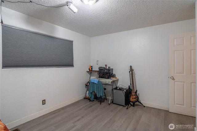 775 S 4th Ave, Othello, WA 99344 - office area featuring wood finished floors, baseboards, and a textured ceiling