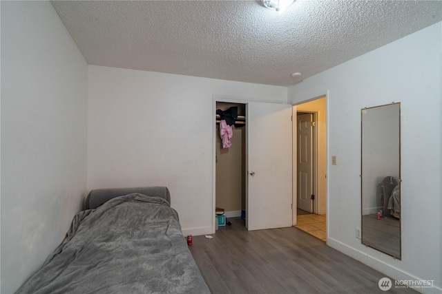 775 S 4th Ave, Othello, WA 99344 - bedroom with wood finished floors, a textured ceiling, and a closet