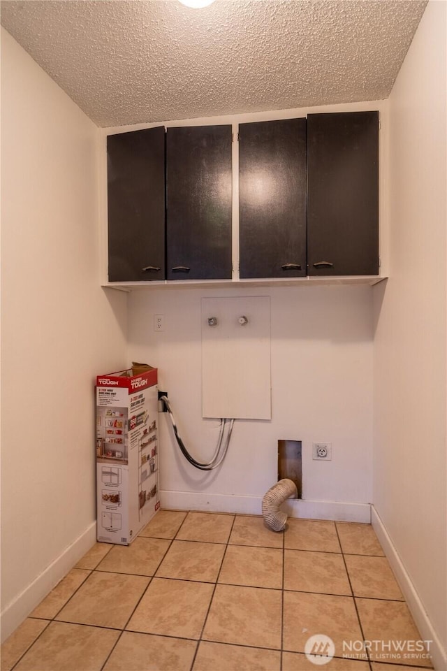 775 S 4th Ave, Othello, WA 99344 - washroom featuring cabinet space, hookup for an electric dryer, a textured ceiling, light tile patterned flooring, and washer hookup