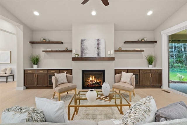 living room with light wood-style flooring, visible vents, and recessed lighting