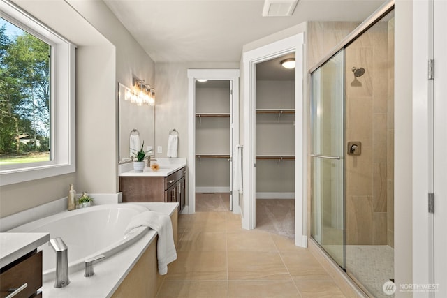 full bath featuring visible vents, a shower stall, tile patterned flooring, a garden tub, and vanity