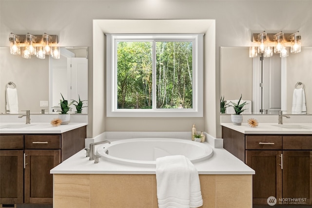 full bathroom featuring a bath, two vanities, and a sink