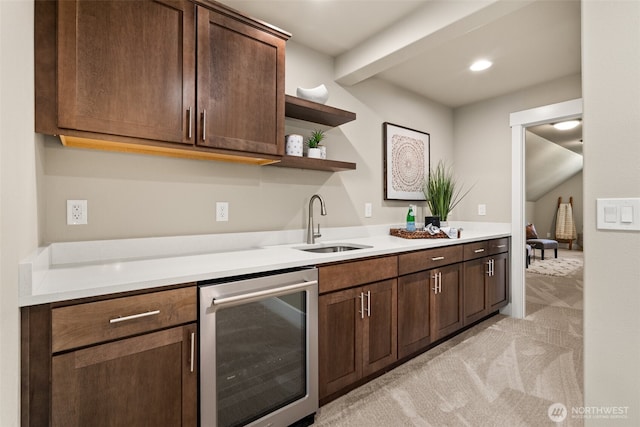 kitchen featuring a sink, open shelves, light colored carpet, light countertops, and wine cooler
