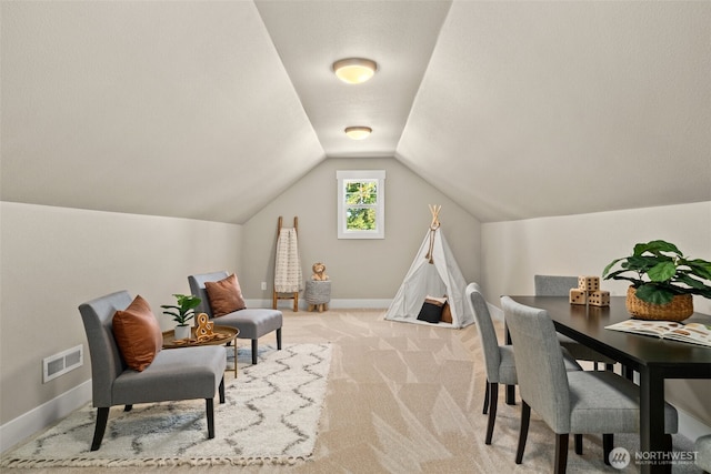 interior space with lofted ceiling, baseboards, visible vents, and light colored carpet