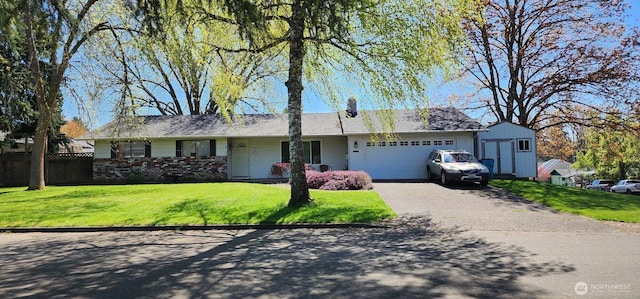 ranch-style home with a front lawn, driveway, a garage, and fence