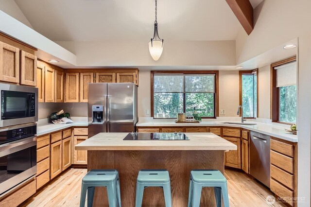 kitchen featuring a sink, appliances with stainless steel finishes, light countertops, light wood-style floors, and recessed lighting
