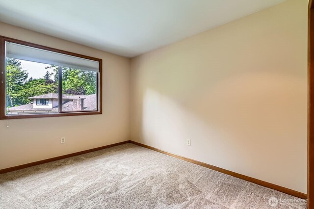 carpeted empty room with baseboards