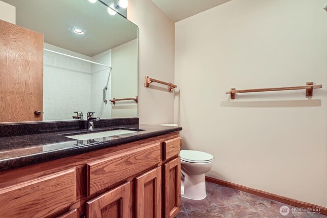 full bath with toilet, a shower, baseboards, and vanity