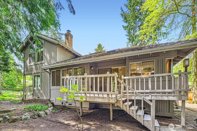 back of property featuring a chimney and a deck