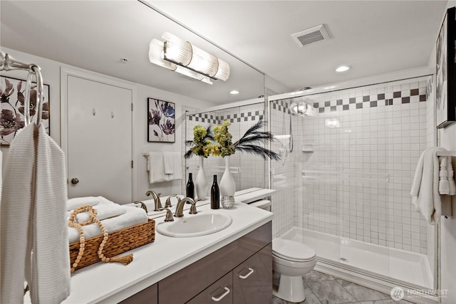 bathroom with a shower stall, toilet, vanity, and visible vents