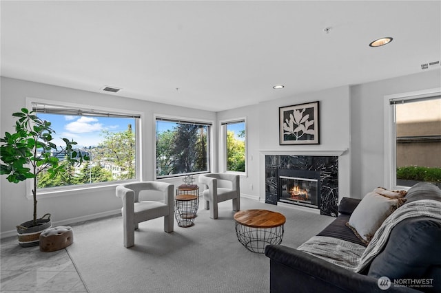 living area featuring visible vents, baseboards, and a premium fireplace