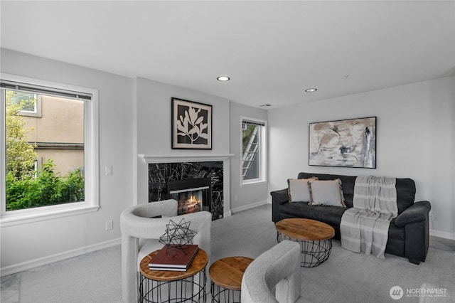 living room featuring baseboards, a healthy amount of sunlight, and carpet
