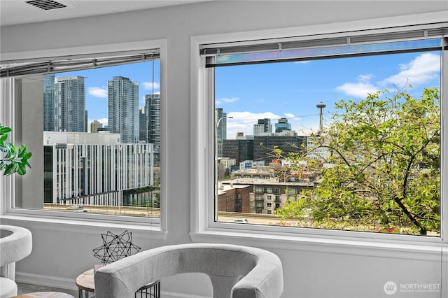 living area featuring a city view, baseboards, and visible vents